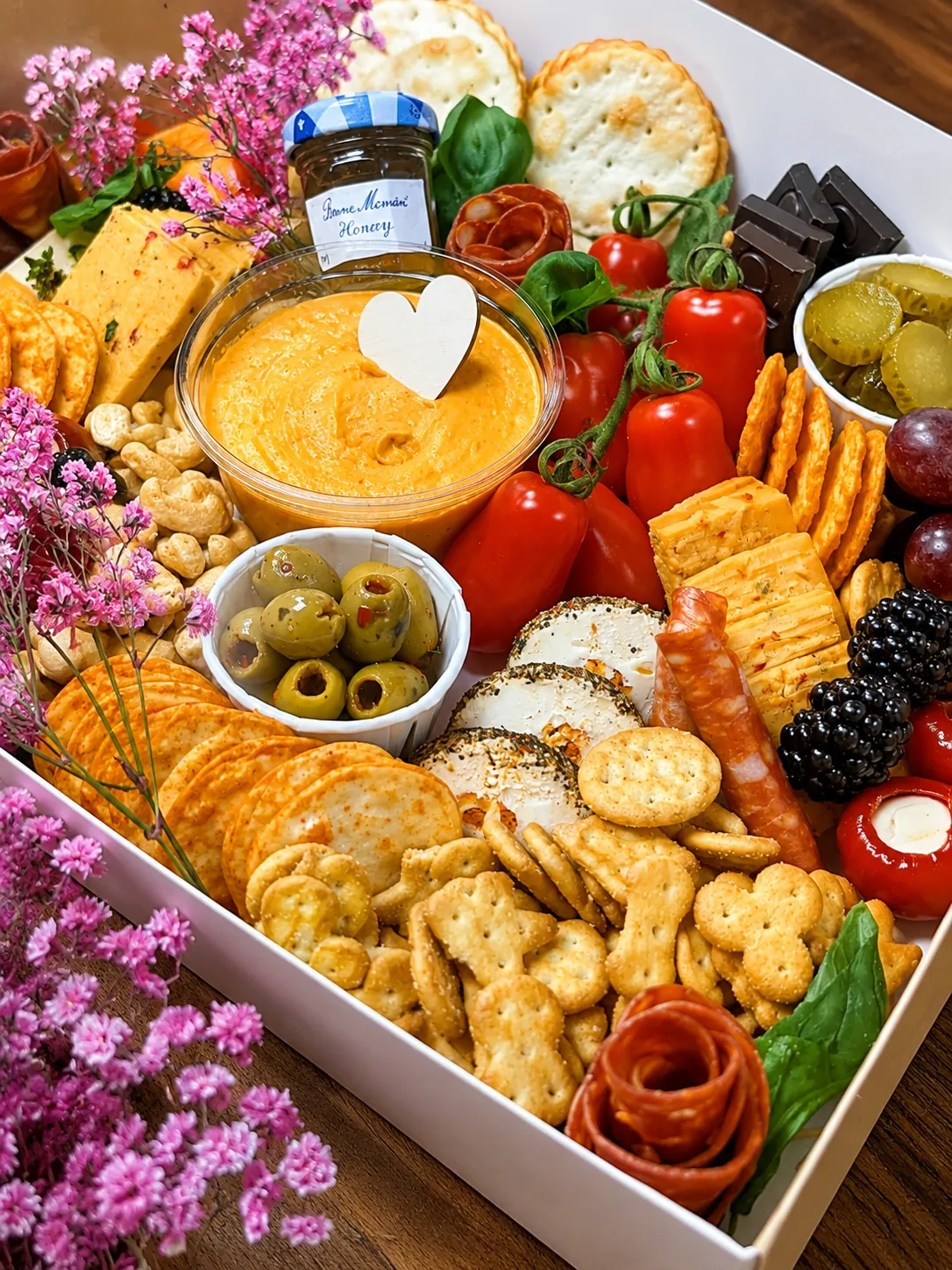 A sharing board with cheese, crackers, fruit and dips